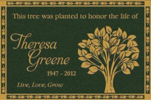 Bronze tree dedication plaque honoring a loved one, mounted in a landscaped setting for outdoor remembrance.